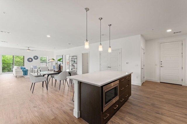 6444 Burnet Rd Unit 204, Austin, TX 78757 - kitchen featuring stainless steel microwave, recessed lighting, wood finished floors, light countertops, and ceiling fan