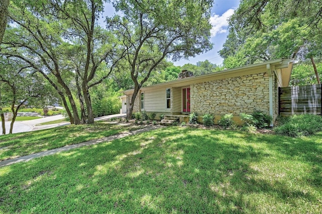 4905 Southcrest Dr, Austin, TX 78746 - view of front of home featuring stone siding, a chimney, a front lawn, and an attached garage