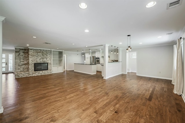 4905 Southcrest Dr, Austin, TX 78746 - unfurnished living room with crown molding, baseboards, recessed lighting, a stone fireplace, and dark wood-style flooring