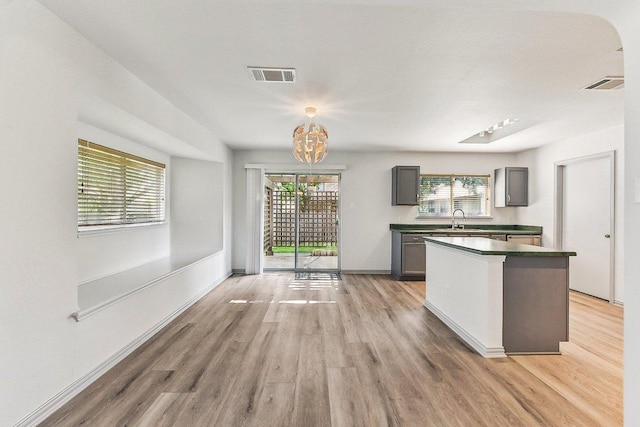 1208 Water Spaniel Way, Round Rock, TX 78664 - kitchen featuring a sink, light wood-type flooring, gray cabinets, a chandelier, and dark countertops