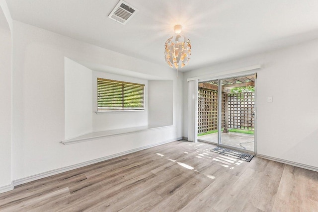 1208 Water Spaniel Way, Round Rock, TX 78664 - empty room with wood finished floors, plenty of natural light, a chandelier, and baseboards