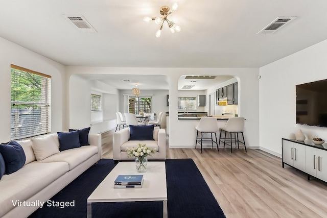 1208 Water Spaniel Way, Round Rock, TX 78664 - living room featuring a chandelier, light wood finished floors, and healthy amount of natural light