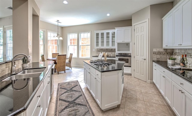 3508 Red River St, Austin, TX 78705 - kitchen featuring appliances with stainless steel finishes, a sink, decorative backsplash, white cabinets, and recessed lighting