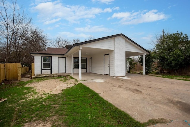 1317 Mckie Cv, Austin, TX 78752 - view of front of home with an attached carport, fence, driveway, and brick siding