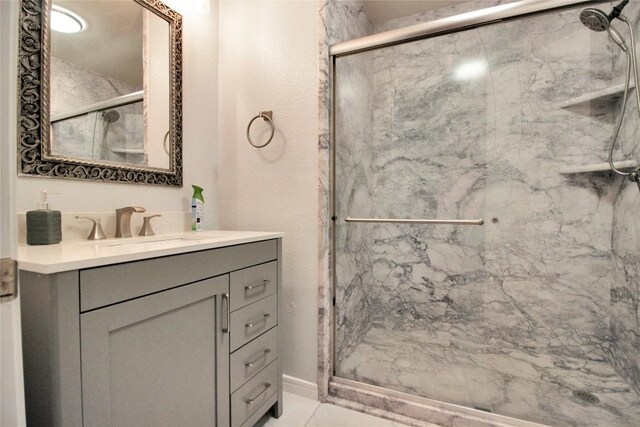 bathroom featuring a marble finish shower and vanity
