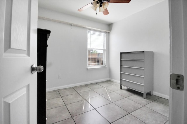 unfurnished bedroom with tile patterned floors, baseboards, and ceiling fan