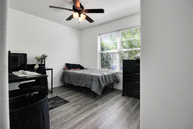 bedroom with wood finished floors, ceiling fan, and baseboards