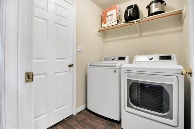 washroom with washing machine and dryer, dark wood finished floors, and baseboards
