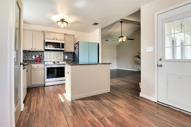 kitchen with stainless steel microwave, range with electric stovetop, fridge, backsplash, and dark wood-style flooring