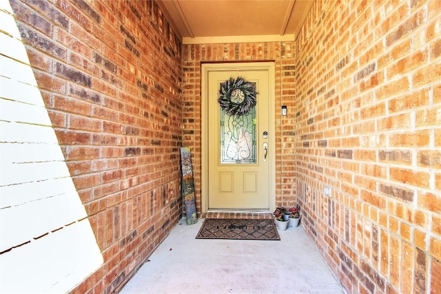 view of exterior entry featuring brick siding