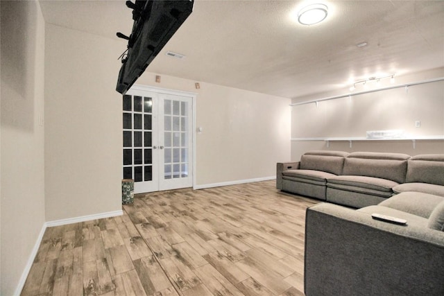 living room featuring french doors, wood finished floors, and baseboards