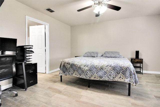 bedroom featuring a desk, baseboards, light wood-style flooring, and a ceiling fan