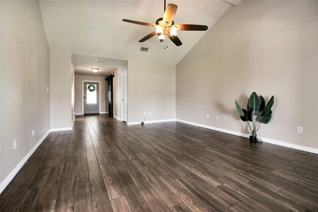 unfurnished living room with lofted ceiling, ceiling fan, dark wood finished floors, and baseboards