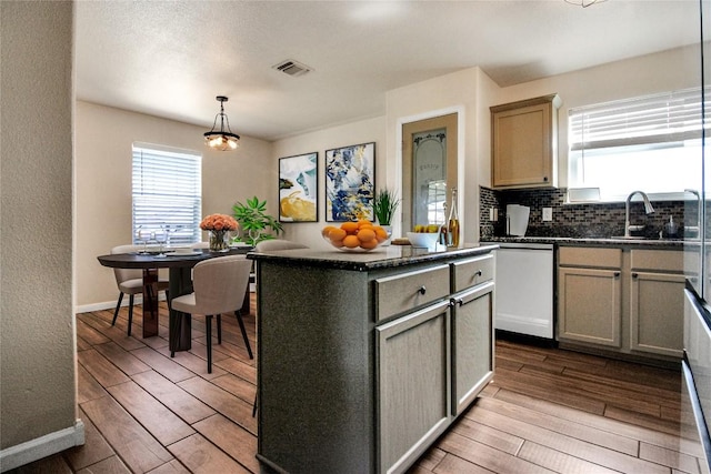 kitchen featuring a sink, healthy amount of natural light, dark wood-style floors, and dishwasher