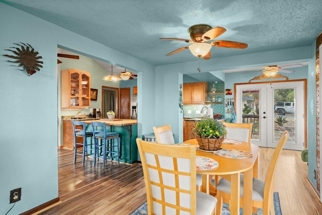 6906 Chinook Dr, Austin, TX 78736 - dining room featuring light wood-style flooring, a ceiling fan, french doors, and a textured ceiling