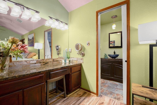 6906 Chinook Dr, Austin, TX 78736 - bathroom with lofted ceiling, vanity, and wood finished floors