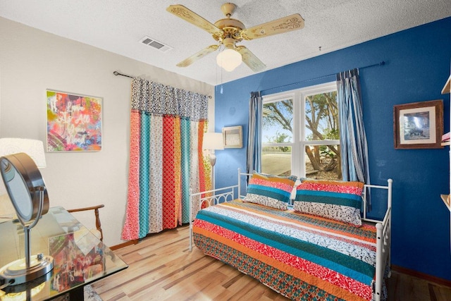 6906 Chinook Dr, Austin, TX 78736 - bedroom with wood finished floors, a textured ceiling, and a ceiling fan