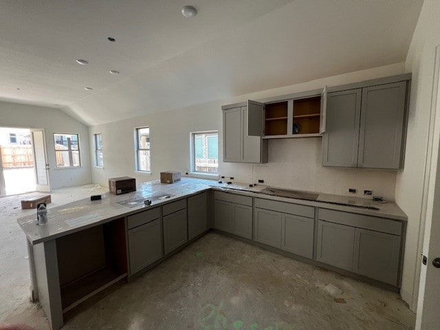 510 Durian Loop, Buda, TX 78610 - kitchen featuring gray cabinetry, vaulted ceiling, concrete flooring, open shelves, and a peninsula