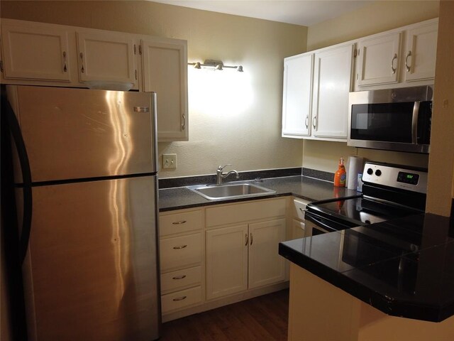 1000 W 26th St Unit 110, Austin, TX 78705 - kitchen with stainless steel appliances, a sink, dark countertops, and white cabinetry
