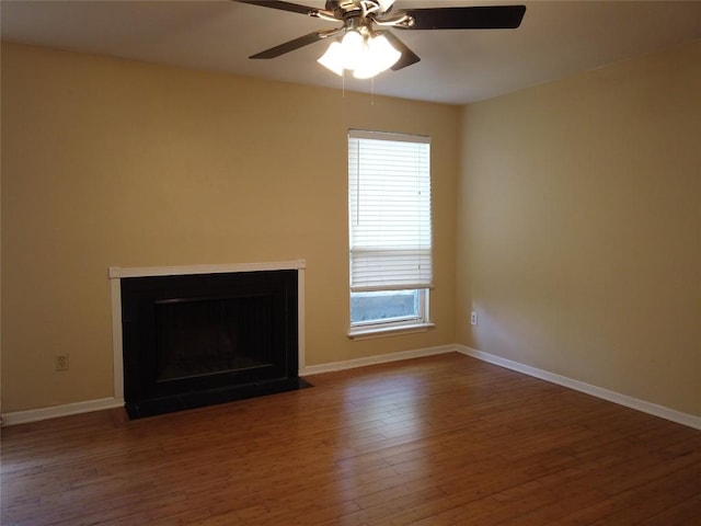 1000 W 26th St Unit 110, Austin, TX 78705 - unfurnished living room with wood finished floors, a ceiling fan, baseboards, and a fireplace with flush hearth