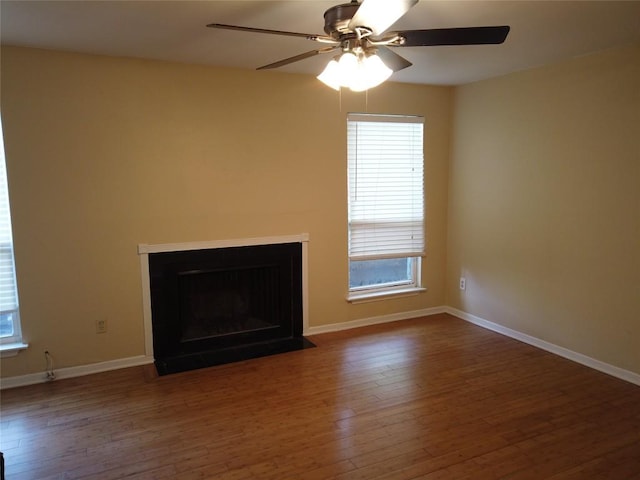 1000 W 26th St Unit 110, Austin, TX 78705 - unfurnished living room featuring hardwood / wood-style floors, a ceiling fan, baseboards, and a fireplace with flush hearth