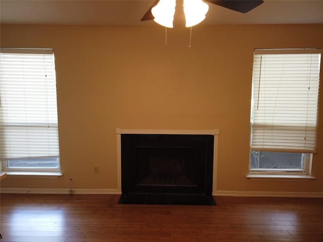 1000 W 26th St Unit 110, Austin, TX 78705 - detailed view of a ceiling fan, wood finished floors, baseboards, and a fireplace with flush hearth
