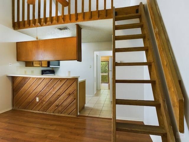 2210 Pearl St Unit 306, Austin, TX 78705 - kitchen with light wood-type flooring, brown cabinets, baseboards, and light countertops