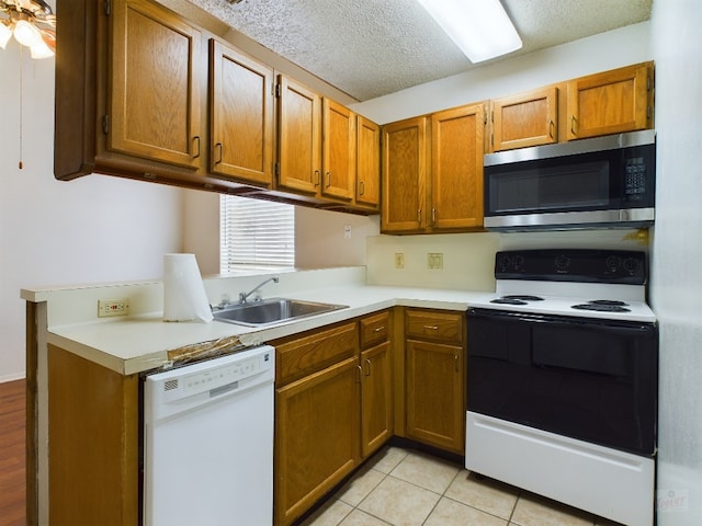 2210 Pearl St Unit 306, Austin, TX 78705 - kitchen with stainless steel microwave, white dishwasher, electric stove, a sink, and light countertops