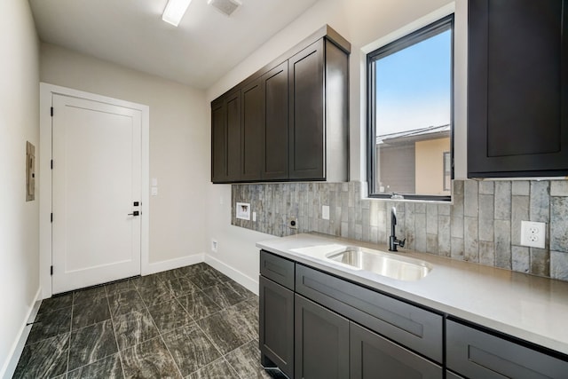 2308 Kahala Sunset Dr, Spicewood, TX 78669 - kitchen featuring a sink, baseboards, light countertops, and decorative backsplash