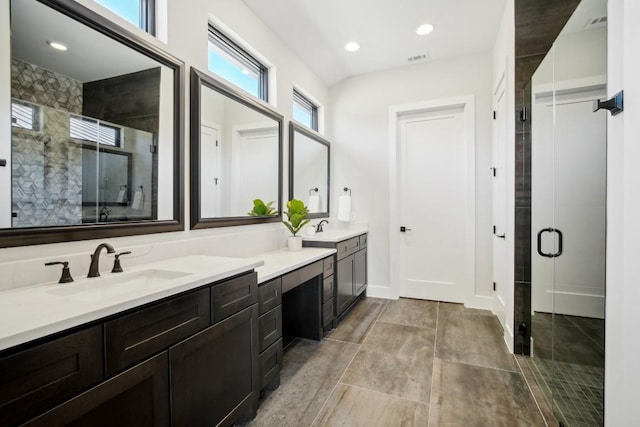 2308 Kahala Sunset Dr, Spicewood, TX 78669 - bathroom featuring a shower stall, double vanity, baseboards, and recessed lighting
