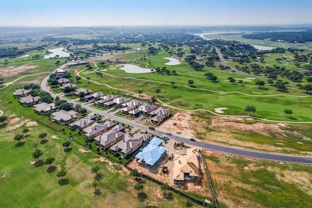 view of property location with a golf club, nearby suburban area, and a large body of water