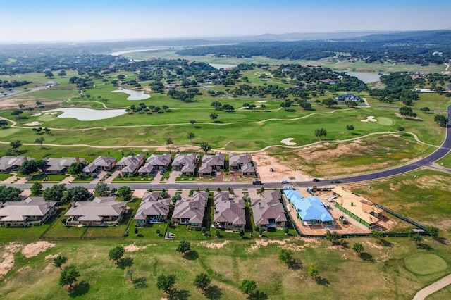 view of property location with a large body of water, a golf club, and nearby suburban area