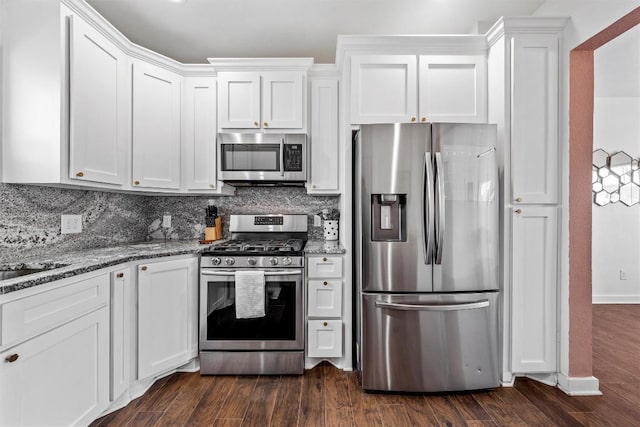 3225 Homan Ave, Waco, TX 76707 - kitchen with appliances with stainless steel finishes, white cabinetry, decorative backsplash, light stone countertops, and dark wood-style flooring