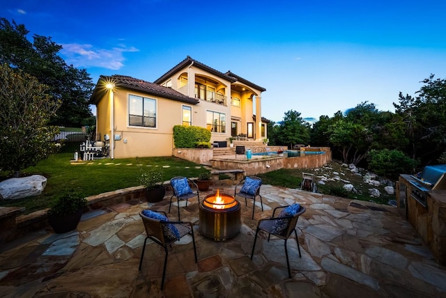 4020 Texas Wildlife Trl, Austin, TX 78735 - back of house featuring an outdoor fire pit, a lawn, a patio, a tiled roof, and stucco siding