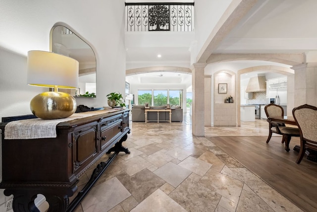 4020 Texas Wildlife Trl, Austin, TX 78735 - foyer entrance featuring stone tile flooring, decorative columns, arched walkways, and a high ceiling