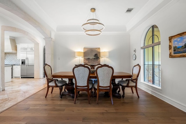 4020 Texas Wildlife Trl, Austin, TX 78735 - dining room with a chandelier, light wood-style floors, ornamental molding, and arched walkways