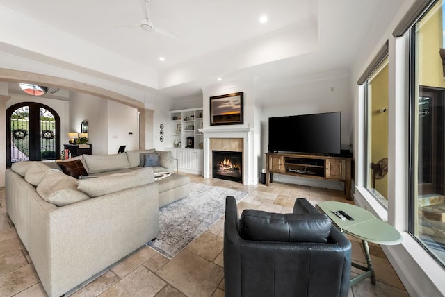 4020 Texas Wildlife Trl, Austin, TX 78735 - living room with a tray ceiling, arched walkways, a fireplace, stone tile floors, and recessed lighting