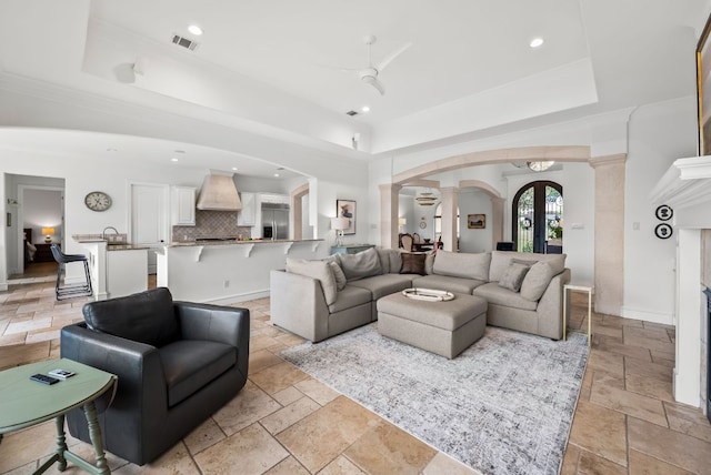 4020 Texas Wildlife Trl, Austin, TX 78735 - living area featuring decorative columns, a tray ceiling, stone tile flooring, arched walkways, and recessed lighting