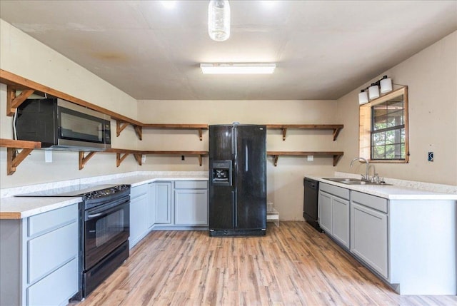 990 Oak Mdws, San Marcos, TX 78666 - kitchen with open shelves, black appliances, a sink, and light wood-type flooring