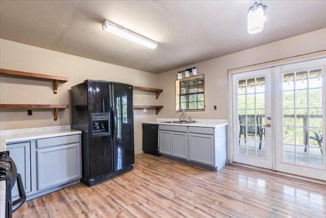 990 Oak Mdws, San Marcos, TX 78666 - kitchen with open shelves, black appliances, a sink, light wood-style flooring, and french doors