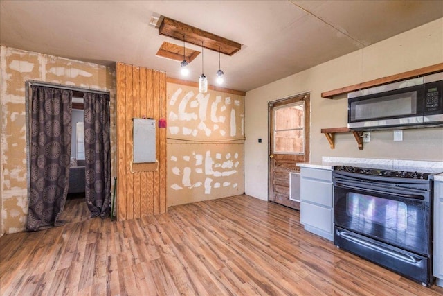 990 Oak Mdws, San Marcos, TX 78666 - kitchen featuring black electric range oven, stainless steel microwave, wood finished floors, and pendant lighting