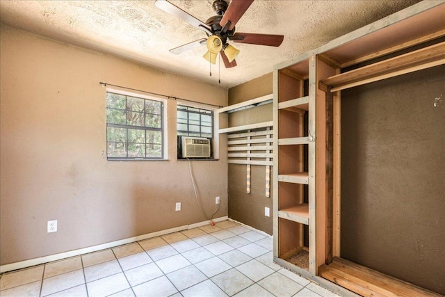 990 Oak Mdws, San Marcos, TX 78666 - unfurnished bedroom with light tile patterned floors, cooling unit, baseboards, and a textured ceiling