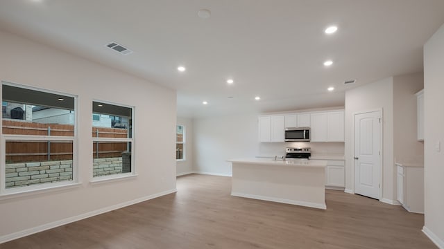 329 Lone Cedar Rd, Marble Falls, TX 78654 - kitchen with stainless steel appliances, light wood-type flooring, a kitchen island with sink, white cabinets, and recessed lighting