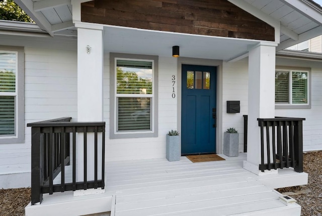 view of exterior entry featuring covered porch