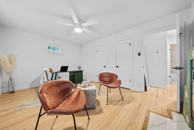 office space with light wood finished floors, a ceiling fan, and baseboards