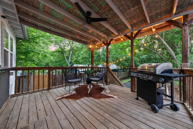 wooden terrace with grilling area and a ceiling fan