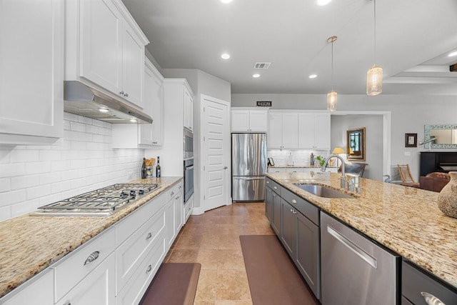 128 Tuscany Way, Georgetown, TX 78633 - kitchen with appliances with stainless steel finishes, under cabinet range hood, a sink, white cabinetry, and recessed lighting