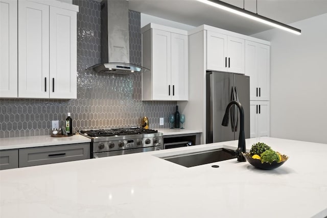 3705 Wilson St Unit 1, Austin, TX 78704 - kitchen featuring wall chimney exhaust hood, range, backsplash, freestanding refrigerator, and white cabinets