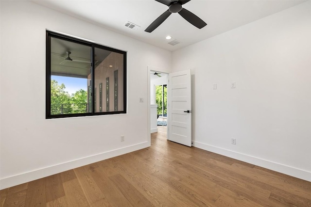 empty room featuring baseboards, ceiling fan, wood finished floors, and recessed lighting