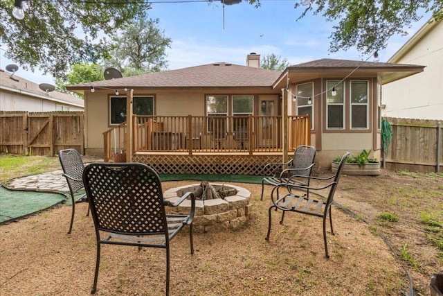 110 Hummingbird Ct, Cedar Creek, TX 78612 - rear view of property featuring an outdoor fire pit, a fenced backyard, a deck, and roof with shingles